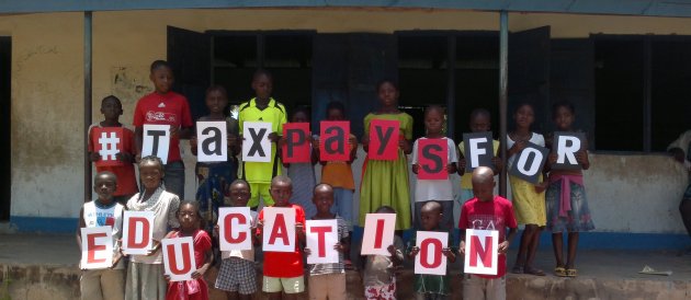 Pupils at the Activista Free Holiday Coaching Lesson in Tionsha community in Benue State Nigeria taking action as part of the Tax Power Campaign 