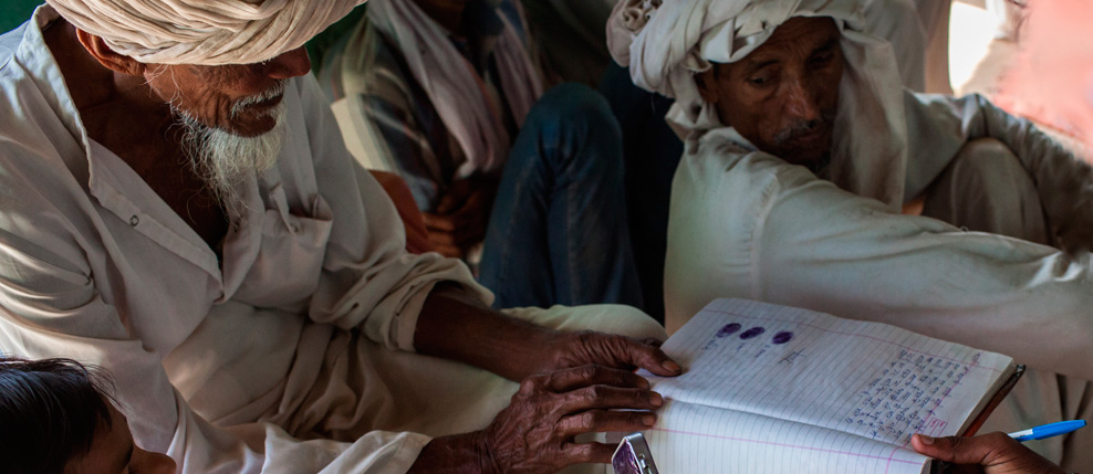 India. Alwar. During a Shiksha Panchayat meeting in Bidarka colony school. An illiterate senior member giving his thumb impression on the signature list