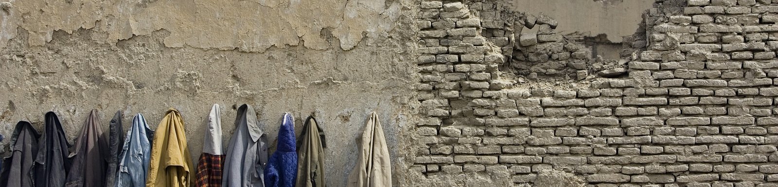 Afghan students' coats hanged on the wall destroyed by the war, Kabul, Afghanistan Afghan students' coats hanged on the wall destroyed by the war, Kabul, Afghanistan